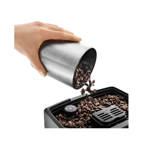Un collaborateur remplit le bac à grains d'une machine à café professionnelle.