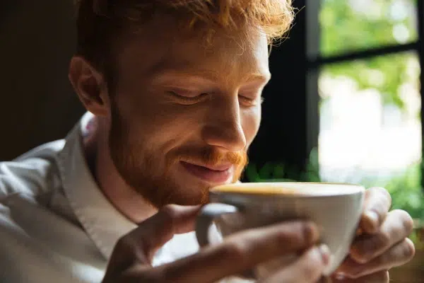 Un homme savoure son café, préparé avec du café grain torréfié dans un ESAT.