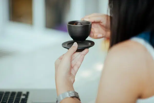 Une collaboratrice se régale avec un café préparé à l'aide d'une machine à café grain.