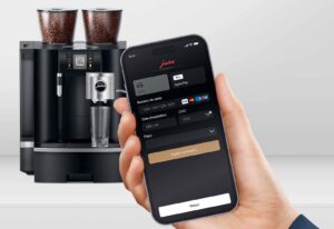 Une belle machine à café avec un monnayeur et un smartphone comme moyen de paiement